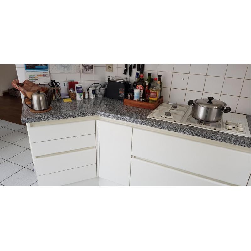 Een ingebouwde keuken greeploos uitgevoerd in witte laminaat in u-vorm