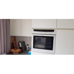 Een ingebouwde keuken greeploos uitgevoerd in witte laminaat in u-vorm