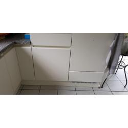 Een ingebouwde keuken greeploos uitgevoerd in witte laminaat in u-vorm