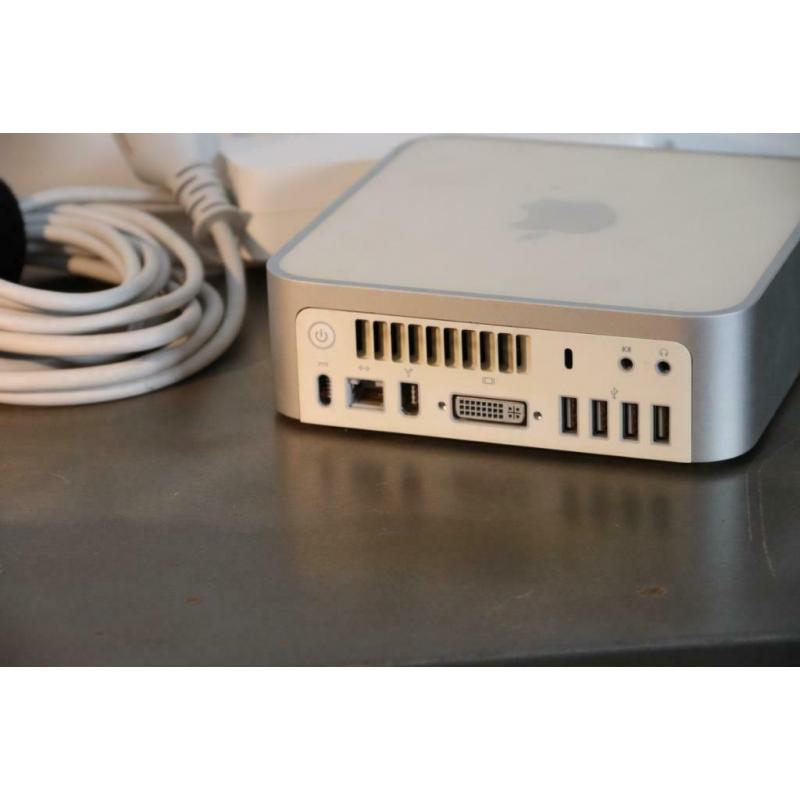 Te Koop Mac Mini 2.1 Intel Core 2 Duo 64 Bit Computer YM8432JDYL1 met 1,83 Ghz en de Stroomadapter en een Wit Apple Toetsenbord en Apple Mighty Mouse en een Videoadapter.