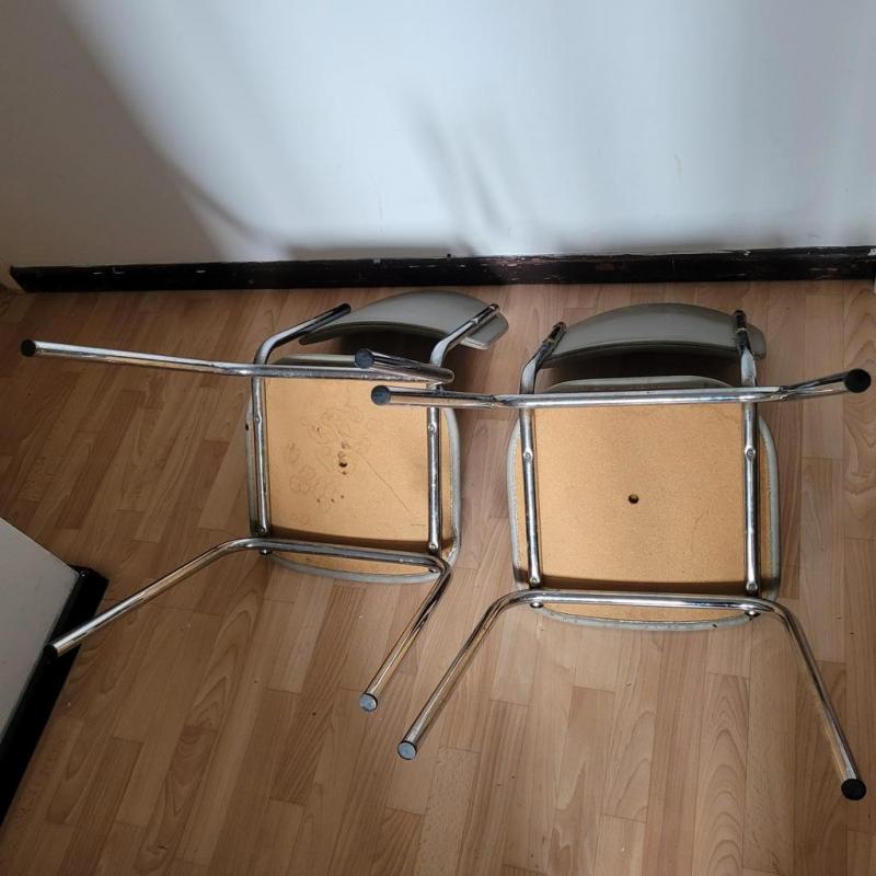 Paar grijze kunstleren stoelen met chromen onderstel